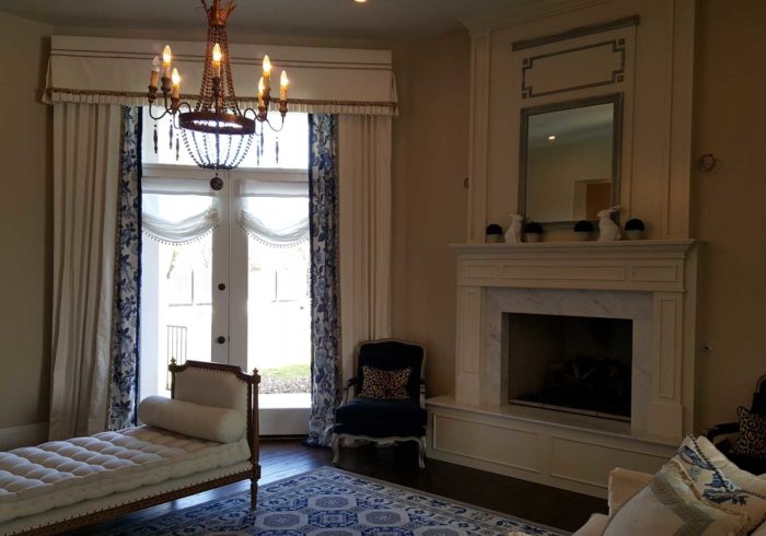 bedroom space with fireplace and a window with multiple layers of curtains