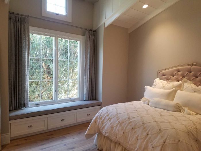 bedroom with large window with drawn drapes