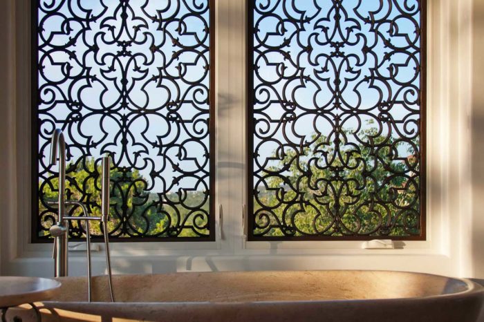 basin with water taps, next to ornate metalwork on windows